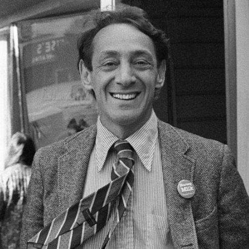 Harvey Milk in Black and White smiling at the camera during one of his political campaigns