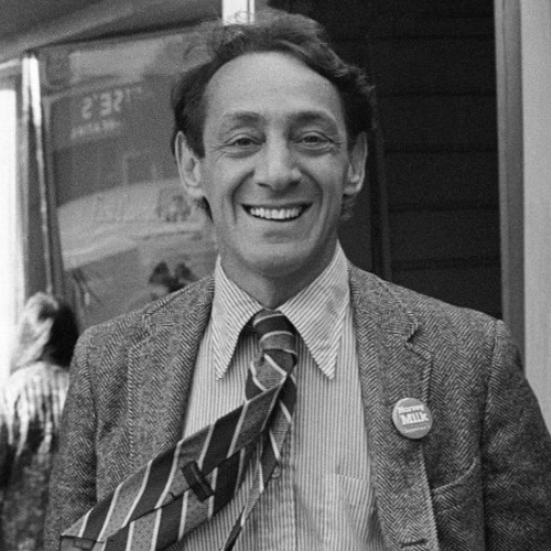 Harvey Milk in Black and White smiling at the camera during one of his political campaigns 