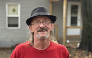 Supportive housing tenant in front of his home.
