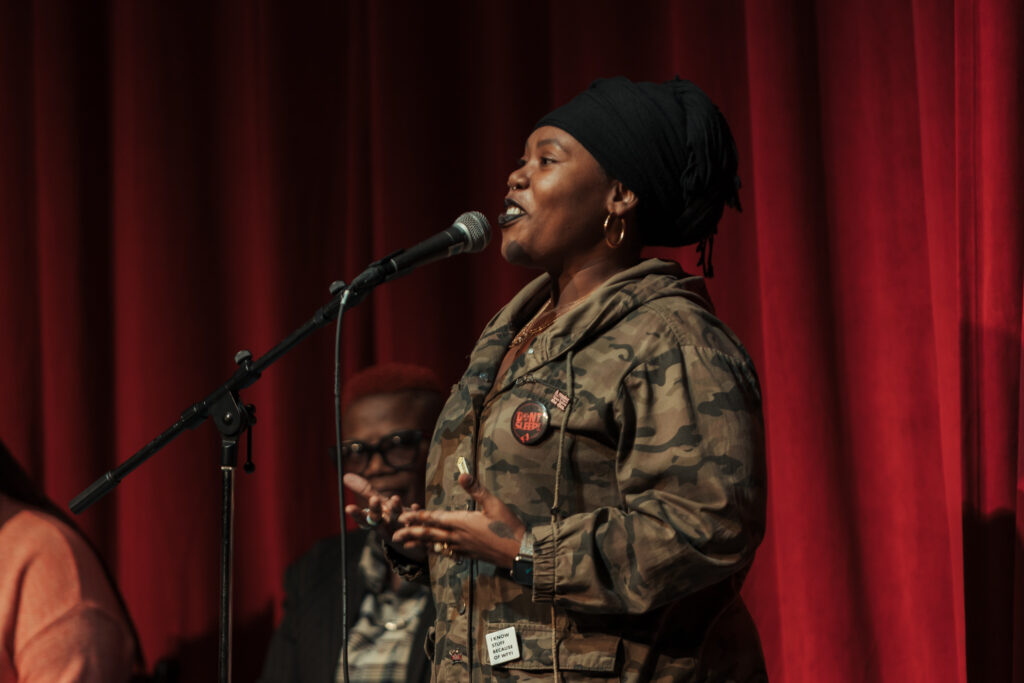 a person speaking in front of a microphone smiling