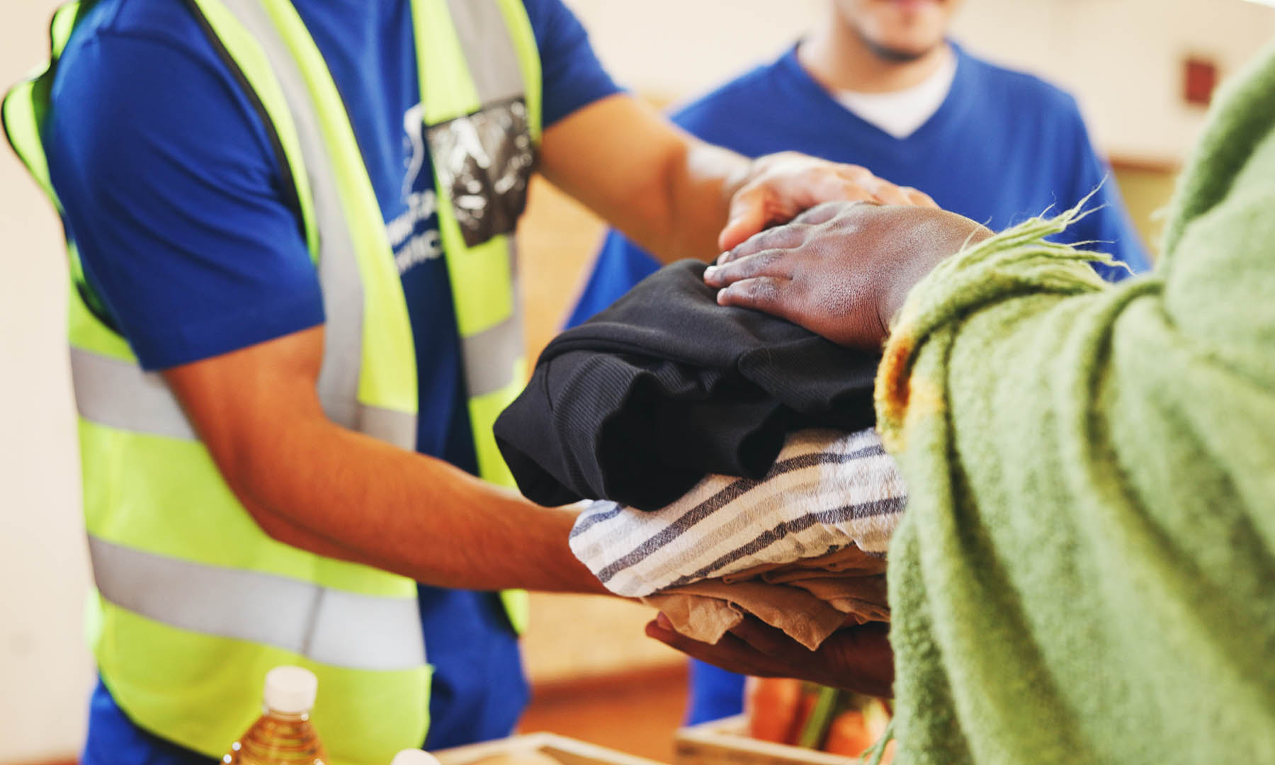Clothes, help or hands with donation for homeless person, social project or community relief. Charity, group or people giving blankets for humanitarian aid, distribution or winter with support at NGO